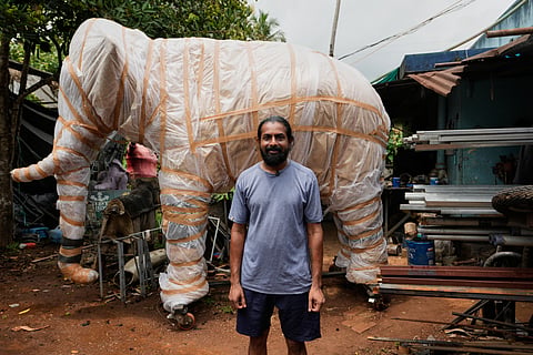 Prasanth Prakashan, a mechanical engineer, poses in front of a robotic elephant at his backyard workshop in Chalakudy, in the southern Indian state of Kerala, 22 May 2026.