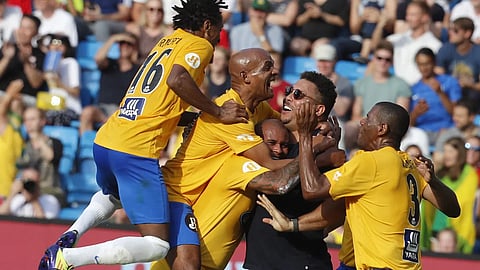 Brazil veterans celebrate with coach Ronaldo Nazario after scoring against Norway.