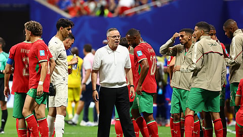 Morocco coach Mohamed Ouahbi gives instructions to his players during a hydration break.