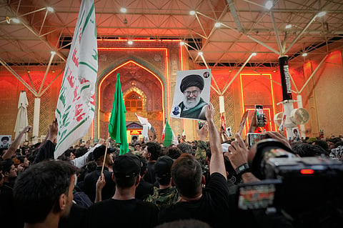 Mourners wave Shiite religious flags and a portrait of the late Iranian Supreme Leader Ayatollah Ali Khamenei outside the Imam Ali Shrine on the eve of funeral ceremonies in Najaf, Iraq, 7 July 2026.