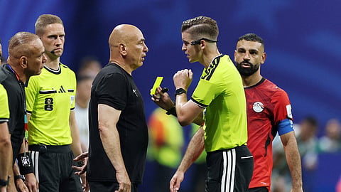 Egypt coach Hossam Hassan is shown a yellow card by referee Francois Letexier