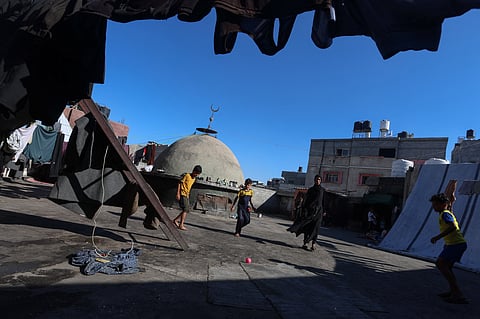 Children play with a ball as Palestinians displaced during an Israeli offensive shelter at a mosque in Khan Younis, in the southern Gaza Strip, 14 July 2026.