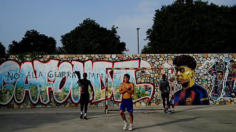 Residents play in a soccer court in a park at Rocafonda neighbourhood in front of Lamine Yamal mural in Mataro, north of Barcelona
