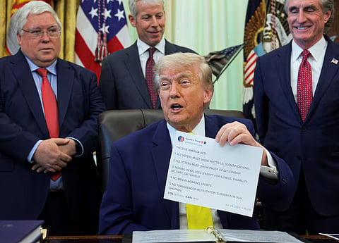U.S. President Donald Trump shows a printout of his Truth Social post as he delivers remarks to reporters in the Oval Office at the White House in Washington, D.C., U.S., June 4, 2026.