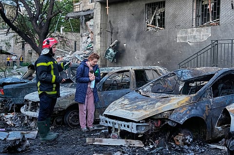 An owner looks at her damaged car following a Russia missile attack in Kyiv, Ukraine,19 July 2026.