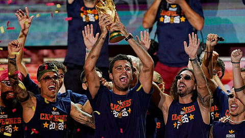 Spain's Rodri celebrates with the World Cup trophy and teammates on stage at Cibeles Square in Madrid after the victory parade as fans gather to celebrate winning the World Cup