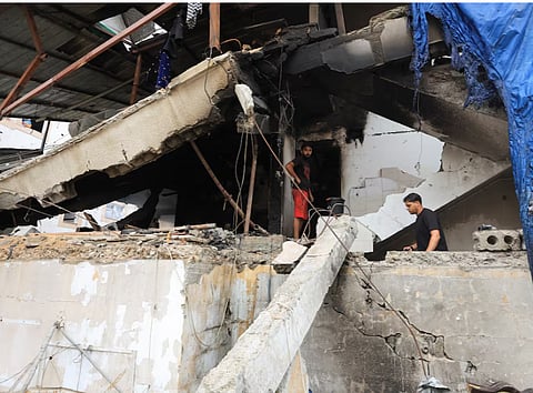 Palestinians inspect the site of an Israeli strike on a house in Gaza City, July 21, 2026