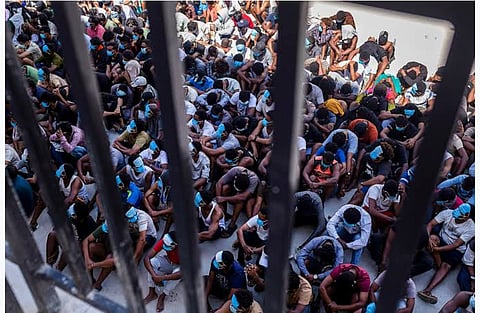 Rescued workers sit inside a detention compound following a crackdown on an alleged cyber scam operation.