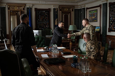 In this photo provided by the Ukrainian Presidential Press Office, Ukrainian President Volodymyr Zelenskyy, center, shakes hands with new commander-in-chief of Ukraine's Armed Forces Mykhailo Drapatyi during their meeting in Kyiv, Ukraine, Monday, July 20, 2026.