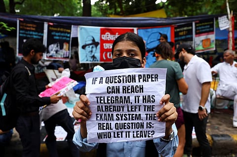 A supporter of India's Cockroach Janata Party (CJP) holds a sign during the ongoing protests, a few days after thousands of protesters marched towards parliament demanding the resignation of Education Minister Dharmendra Pradhan over National Eligibility cum Entrance Test (NEET) examination paper leaks, at Jantar Mantar in New Delhi, India, July 23, 2026. 