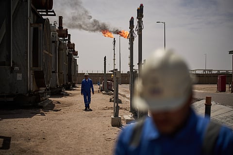 Workers walk in the Zubair oil field, whose operations have being reduced since the start of the Iran war, near Basra, Iraq, March 28, 2026. 
