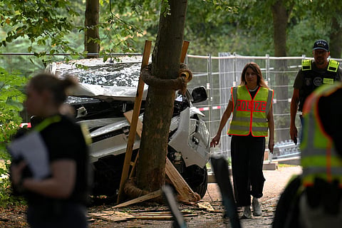 Police walk next to a vehicle which crashed into a crowd near Berlin's annual Christopher Street Day Pride parade on Saturday evening, leaving multiple people injured and the parade called off, in Berlin, Germany, July 26, 2026.