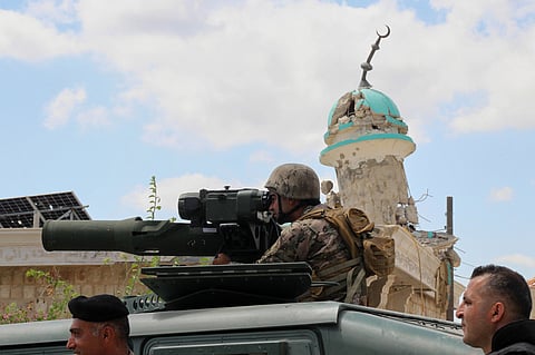 A Lebanese soldier looks through the binoculars of an anti-tank launcher in front of a destroyed mosque after deploying in the village of Zawtar al-Gharbiyeh, southern Lebanon, Sunday, July 26, 2026.