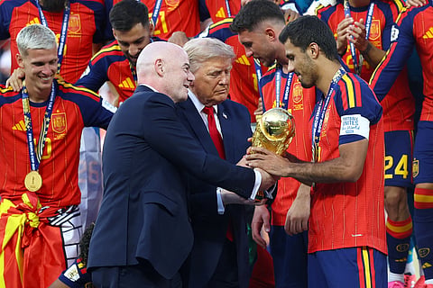 FIFA President Gianni Infantino (L) and US President Donald Trump hand the World Cup trophy to Spain's Rodri ahead of the trophy lift.