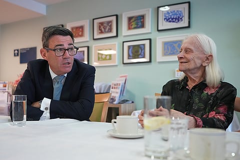Britain's Prime Minister Andy Burnham speaks to a resident as he visits a care home in London, Wednesday, July 29, 2026.