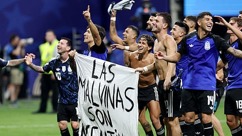 Argentina's Lisandro Martinez and Giovani Lo Celso celebrate with a Falkland Islands related banner after the match as Argentina qualify for the final of the World Cup