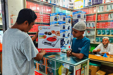 Customers purchasing induction oven in Baitul Mukarram Market in Dhaka