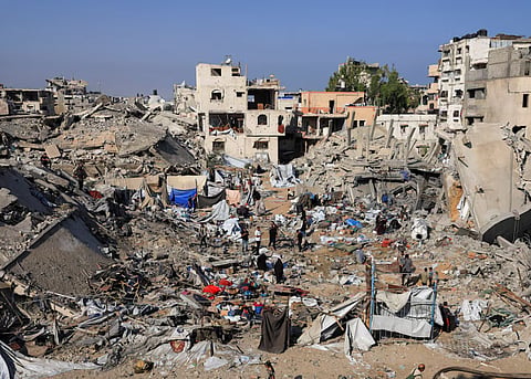Palestinians inspect the site of Wednesday's Israeli strike on a house whose residents were pre-warned by the Israeli military to evacuate, in Gaza City, July 30, 2026.