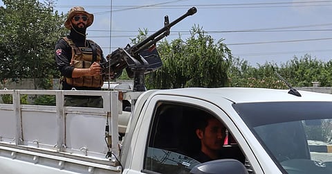 A police officer with a machine gun stands guard at a hospital where injured victims of an overnight deadly militant attack on a police post are being treated, in Hangu, a district in northwestern Pakistan, Thursday, July 30, 2026.