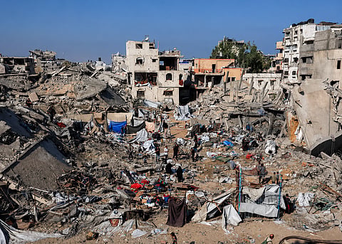 Palestinians inspect the site of Wednesday's Israeli strike on a house whose residents were pre-warned by the Israeli military to evacuate, in Gaza City, July 30, 2026.