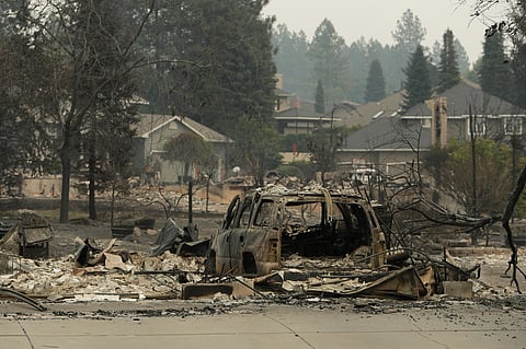 A vehicle and structure are burned on N. Skyline Dr. due to a wildfire, Sunday, Aug. 2, 2026, in Spokane, Wash. 