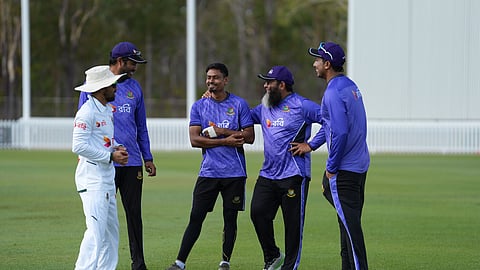 Bangladesh's Taijul Islam (C) with a bandaged left index finger in talks with teammates and spin-bowling coach Mushtaq Ahmed before the second day's play of the ongoing three-day tour match in Darwin on Friday.