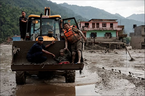 A survivor is transported to a safer place in a JCB following a flash flood at Trishuli in Nuwakot district, Nepal, August 26.