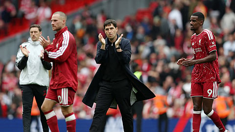 Liverpool manager Andoni Iraola applauds fans after the match.