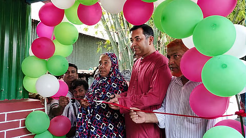 Yaser Khan Chowdhury handing over a house to a recipient 