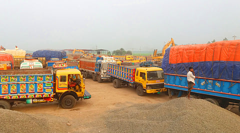 The image shows trucks lined up at the Hili Land Port in Dinajpur on the Bangladesh-India border.