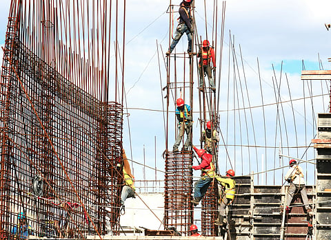 Representational image for migrant workers working on a building construction during the day.