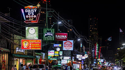 People walk along a street lined with bars and entertainment venues at Jomtien Beach, in Pattaya City, Thailand, June 29, 2026.