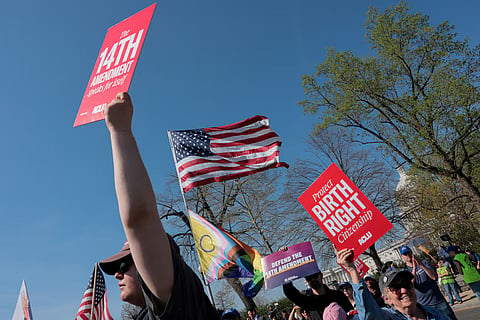 Demonstrators hold placards referencing the Fourteenth Amendment to the US Constitution near the US Capitol and the US Supreme Court building, in Washington, DC, US, April 1, 2026. 