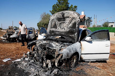 A man walks past destroyed cars, which Palestinians say were burned by Israeli settlers last night, in Beita, near Nablus, in the Israeli-occupied West Bank, September 2, 2026.