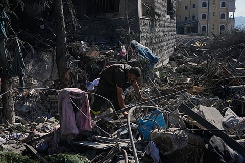 A rescue worker searches for victims under the rubble of a building destroyed in an Israeli airstrike in the southern village of Kfar Rumman, Lebanon, Monday, Sept. 7, 2026.
