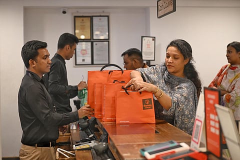 Customers collect their purchases in Aarong’s paper shopping bags at a store in Dhaka.