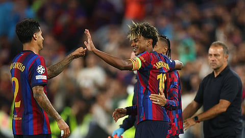 Barcelona's Lamine Yamal celebrates scoring their fourth goal with Raphinha and Joao Cancelo (L) against Feyenoord.
