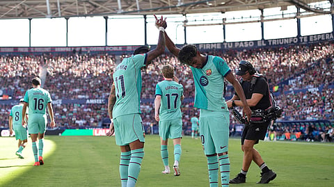 Barcelona's Lamine Yamal celebrates scoring their second goal with Raphinha.