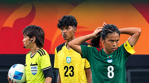 Bangladesh women's football team captain Maria Manda (R), with goalkeeper Mile Akter (C) during their Asian Games match against North Korea in Osaka, Japan on Monday. 
