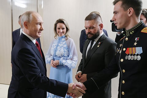Russian President Vladimir Putin, foreground right, speaks with members of the military in the Kremlin in Moscow on Friday, June 12, 2026, as Defense Minister Andrei Belousov, right, stands nearby.