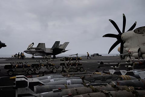 A US Navy sailor runs across the flight deck of the USS George Washington in the Arabian Sea, September 11, 2026. The aircraft carrier, capable of carrying more than 5,000 personnel, is enforcing a US naval blockade against Iran and providing cover for commercial vessels transiting the Strait of Hormuz