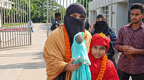 Seven-year old Mobashwera with her mother Kamrunnahar Moni outside of jail