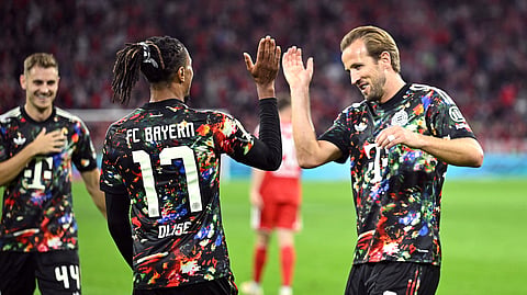 Michael Olise celebrates scoring Bayern Munich's sixth goal with Harry Kane. 
