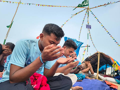 Devotees are praying onboard a bhur, a broad floating platform made from hundreds of bamboo poles lashed together