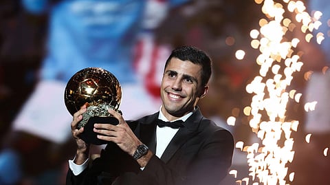 Rodri holds aloft the 2024 Ballon d’Or trophy. 