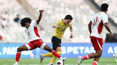 Hamza Choudhury of Bangladesh competes for the ball against Malaysia's Stuart Wilkin.
