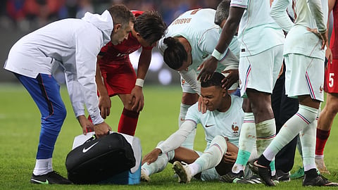 France's Kylian Mbappe receives medical attention after he scores their first goal.