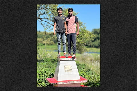 Two youths with shoes on stand on a grave in a cremation ground in Kushtia.  