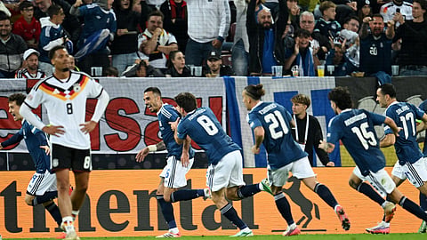 Greece's Dimitrios Kourbelis celebrates scoring their opener with teammates against Germany.