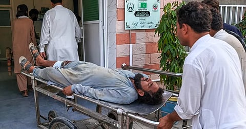 Volunteers transport an injured victim of a suicide attack on a roadside police checkpoint upon his arrival at a hospital in Dera Ismail Khan, Pakistan on September 26, 2026. 